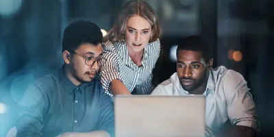 People working together at a laptop looking at the screen