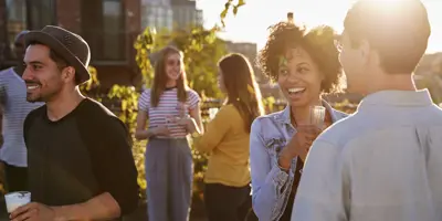 People socializing on an outside terrace at sunset